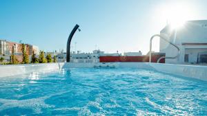 a swimming pool on the roof of a building at Aparthotel Luz de Gades - Suites Spa Gym - Adults Only in Cádiz
