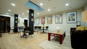 a living room with a couch and tables and chairs at Aparthotel Luz de Gades - Suites Spa Gym - Adults Only in Cádiz