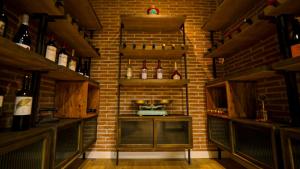 a room with a brick wall with bottles of wine at Aparthotel Luz de Gades - Suites Spa Gym - Adults Only in Cádiz