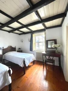 アロウカにあるQuinta de Bócoのベッド2台と机と窓のある寝室