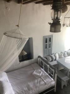 a bedroom with a bed and a table and a mirror at TaVLaDo Cycladic house in Serifos Chora