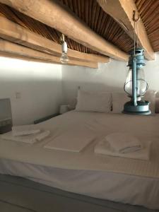 a white bed with a lamp on top of it at TaVLaDo Cycladic house in Serifos Chora