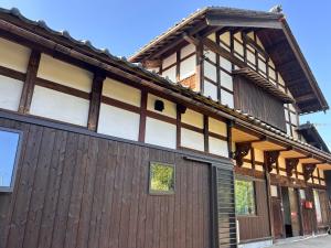 a large wooden building with a garage at Traditional Japanese Style Vacation Rentals ToBay 古民家民泊藤兵衛 in Eiheiji