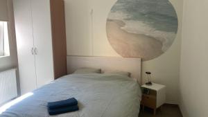 a bedroom with a bed with a large painting on the wall at Appartement met zicht op zee in Knokke-Heist