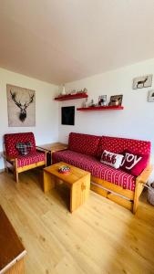 a living room with a red couch and a table at Residence Larici Belvedere in Folgarida