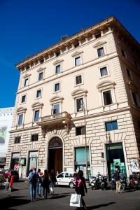 un grand bâtiment avec des personnes qui marchent devant lui dans l'établissement Residenza Pantaleo, à Rome