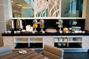 a restaurant with a counter with food on it at Hotel Tamara Melaka in Malacca