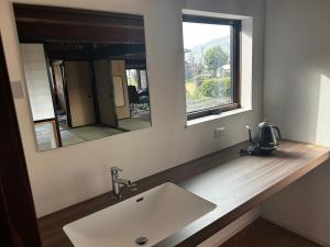 a bathroom with a sink and a mirror at Traditional Japanese Style Vacation Rentals ToBay 古民家民泊藤兵衛 in Eiheiji