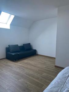un soggiorno con un divano blu in una stanza di Chambres d'hôtes - La correziene ad Allassac