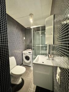 a bathroom with a toilet and a sink and a washing machine at Private room and bathroom in the heart of Drammen in Drammen