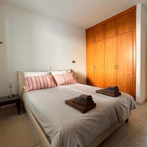 a bedroom with a large bed with two towels on it at Vista Dourada in Porto Santo