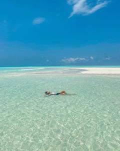 a woman laying in the water on a beach at Ames Nungwi in Nungwi +38 photos