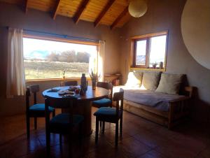 a bedroom with a bed and a table and a window at Tierra Caracol - Casa de Campo Ecológica in Trevelin