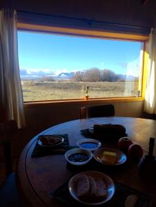 a table with food on it in front of a window at Tierra Caracol - Casa de Campo Ecológica in Trevelin