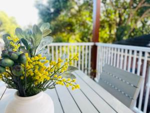 eine weiße Vase mit gelben Blumen auf dem Tisch in der Unterkunft SPR house Chatswood - 3 bedrooms -2 in Sydney