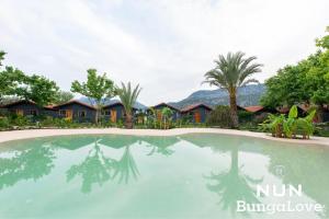 a swimming pool in front of a resort at Çıralı Nun Bungalove in Cıralı