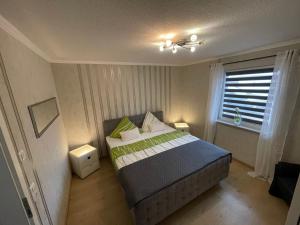 a bedroom with a bed and a window at Haus Karin am See in Bienenbüttel