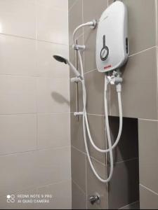 a shower with a white shower head on a wall at Semenyih Setia Ecohill 2 Free Wifi in Beranang +11 photos