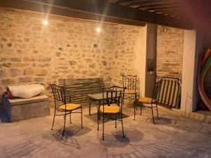 a table and chairs in front of a brick wall at La Maison de Gabriel in Villeneuve-de-Berg +49 photos