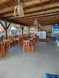 a restaurant with wooden tables and chairs and a kitchen at Aim Bozcaada in Bozcaada +113 photos