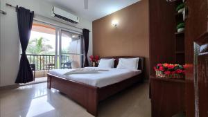 バガにあるGoa Chillout Apartment - 2BHK Baga JAQK Holidaysのベッドルーム1室(ベッド1台付)、窓、バルコニーが備わります。 +23枚の写真