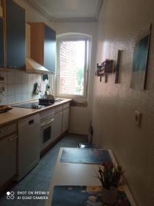 eine kleine Küche mit Tisch und Fenster in der Unterkunft Zimmer in Gostenhof Nürnberg in Nürnberg