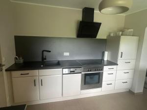 a kitchen with a sink and a stove at Ferienwohnung Morgenblüte in Gondenbrett