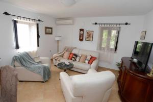 a living room with white furniture and a flat screen tv at Lazovic- Apartment by the Sea with Amazing View in Dobrota