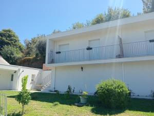 a white house with a balcony on the side of it at Casa Coruja in Ponte da Barca