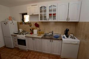 a kitchen with white cabinets and a sink and a refrigerator at Lazovic- Apartment by the Sea with Amazing View in Dobrota