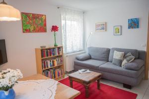 a living room with a couch and a table at Romantische Ferienwohnung in Wüstenrot +4 photos