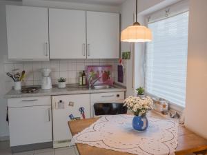 a kitchen with a table with a vase of flowers on it at Romantische Ferienwohnung in Wüstenrot