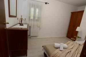 a bedroom with a bed and a dresser and a window at Lazovic- Apartment by the Sea with Amazing View in Dobrota