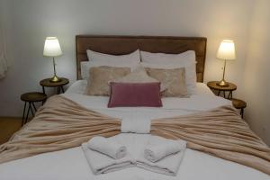 a large bed with towels and pillows on it at Lazovic- Apartment by the Sea with Amazing View in Dobrota