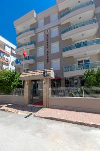 a hotel building with a sign in front of it at Toprak Otel in Antalya