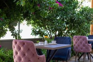 a table with two chairs and a table with cups on it at Toprak Otel in Antalya