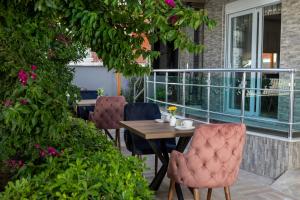 a table and chairs on a patio with flowers at Toprak Otel in Antalya