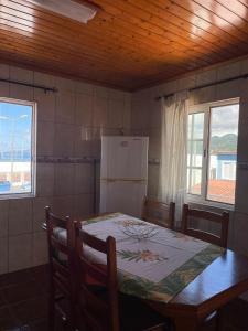 a kitchen with a table and a refrigerator at Casa mãe in Lajes do Pico +10 photos