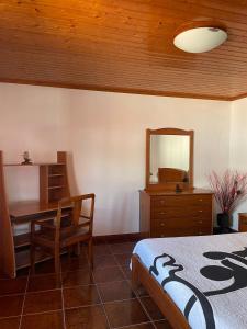 a bedroom with a desk and a table and a mirror at Casa mãe in Lajes do Pico