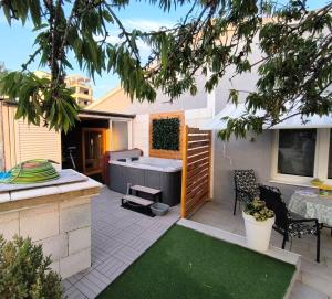 a backyard with a hot tub and a grill at Wellness Apartments Ra in Primošten