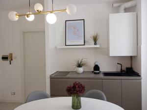 a kitchen with a table with a vase of flowers at Flat 14 Lecco Lake in Calolziocorte