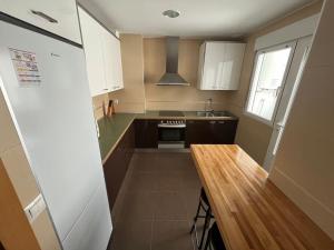 a small kitchen with a wooden table in it at Piso 3 Dormitorios in La Roda
