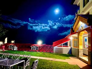 a patio with a table and chairs at night at Hotel Rollingrang in Kalpa