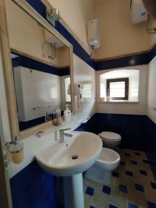 a bathroom with a white sink and a toilet at VILLINO CHELIDONIA SUBIACO in Subiaco