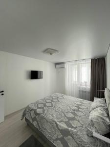 a white bedroom with a bed and a window at Tatiana apartment in Chişinău