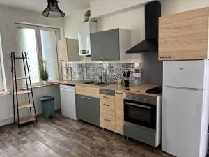 a kitchen with stainless steel appliances and wooden cabinets at A&M Games and spa in Charleville-Mézières