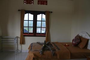 a living room filled with furniture and a window at Santun Homestay in Ubud