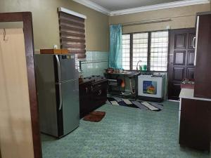 a kitchen with a stainless steel refrigerator in it at Jasmina Homestay in Jitra