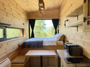 a bedroom in a tiny house with a bed at The Black Lodge in Sohodol