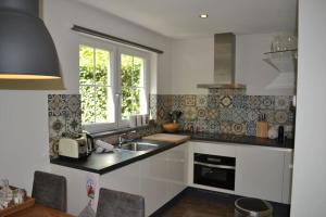 a kitchen with a sink and a window at 400 meter van het strand nieuwe luxe zomerwoning Oostkapelle in Oostkapelle